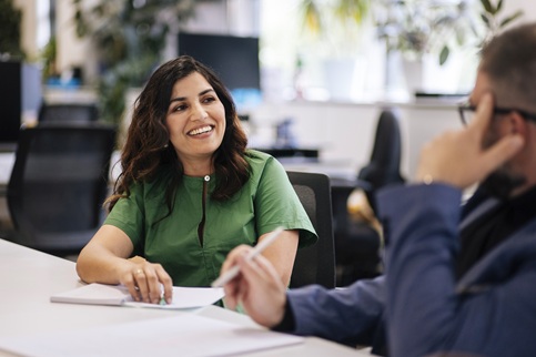 Woman at table talking to a person