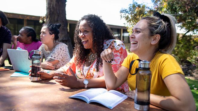 A group of students sitting at a table laughing